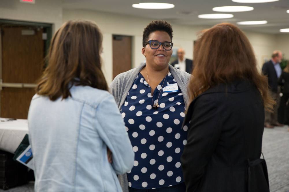 Ayana Weekley chats with two faculty members
